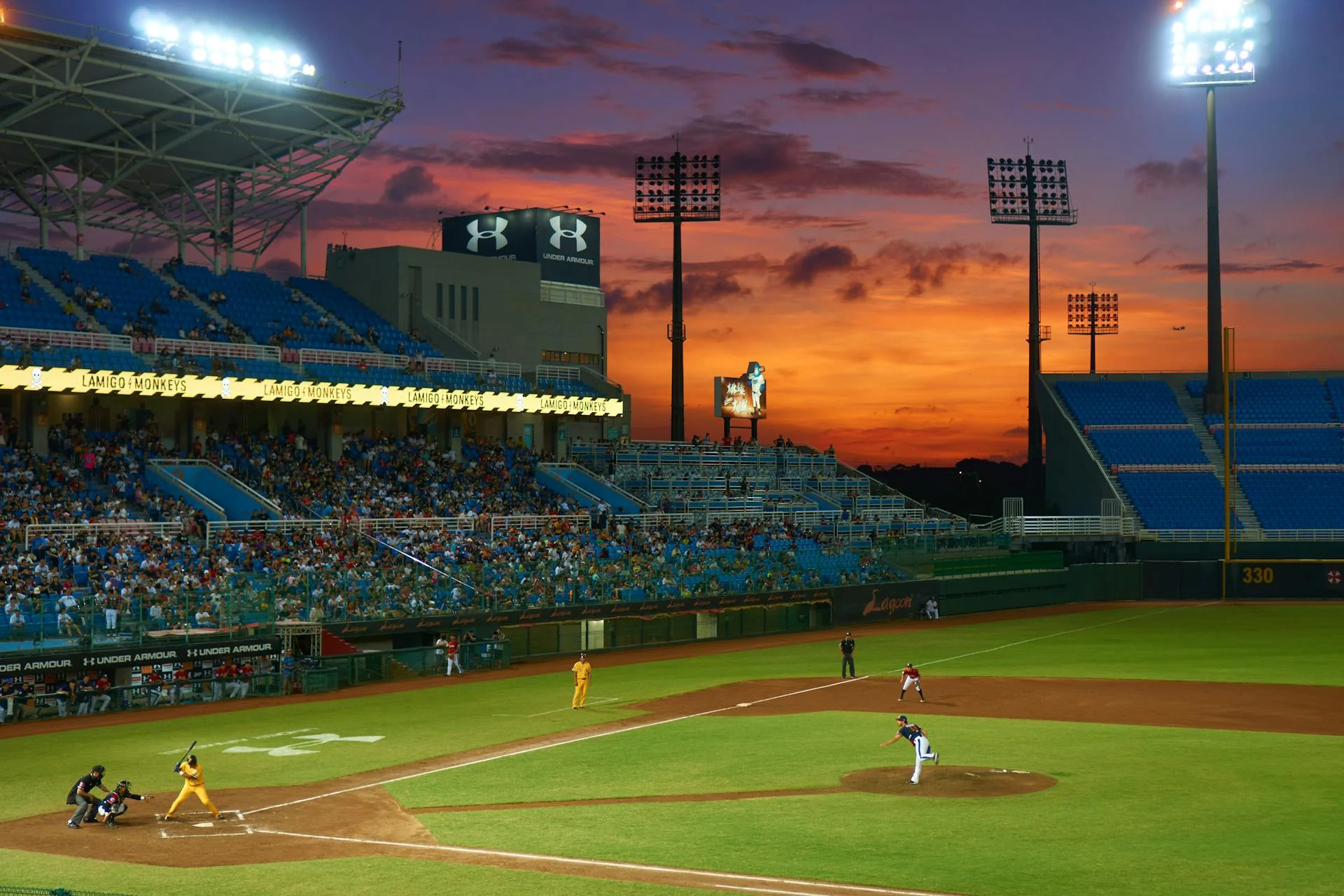 An evening baseball game under the lights with fans filling the stands