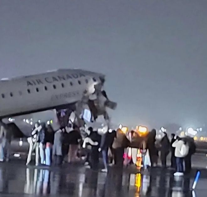 Passengers evacuate the Air Canada Express CRJ-900 on the LaGuardia runway after the collision with a Port Authority fire truck