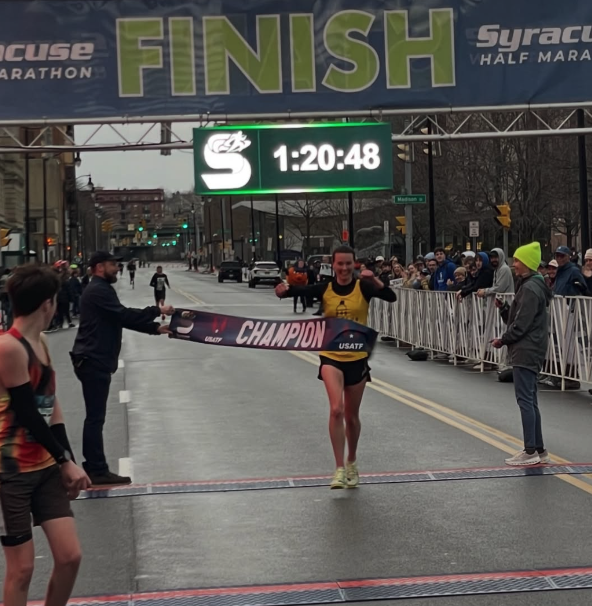 Stephanie Ryan breaks the USATF Champion banner at the 2026 Syracuse Half Marathon finish line