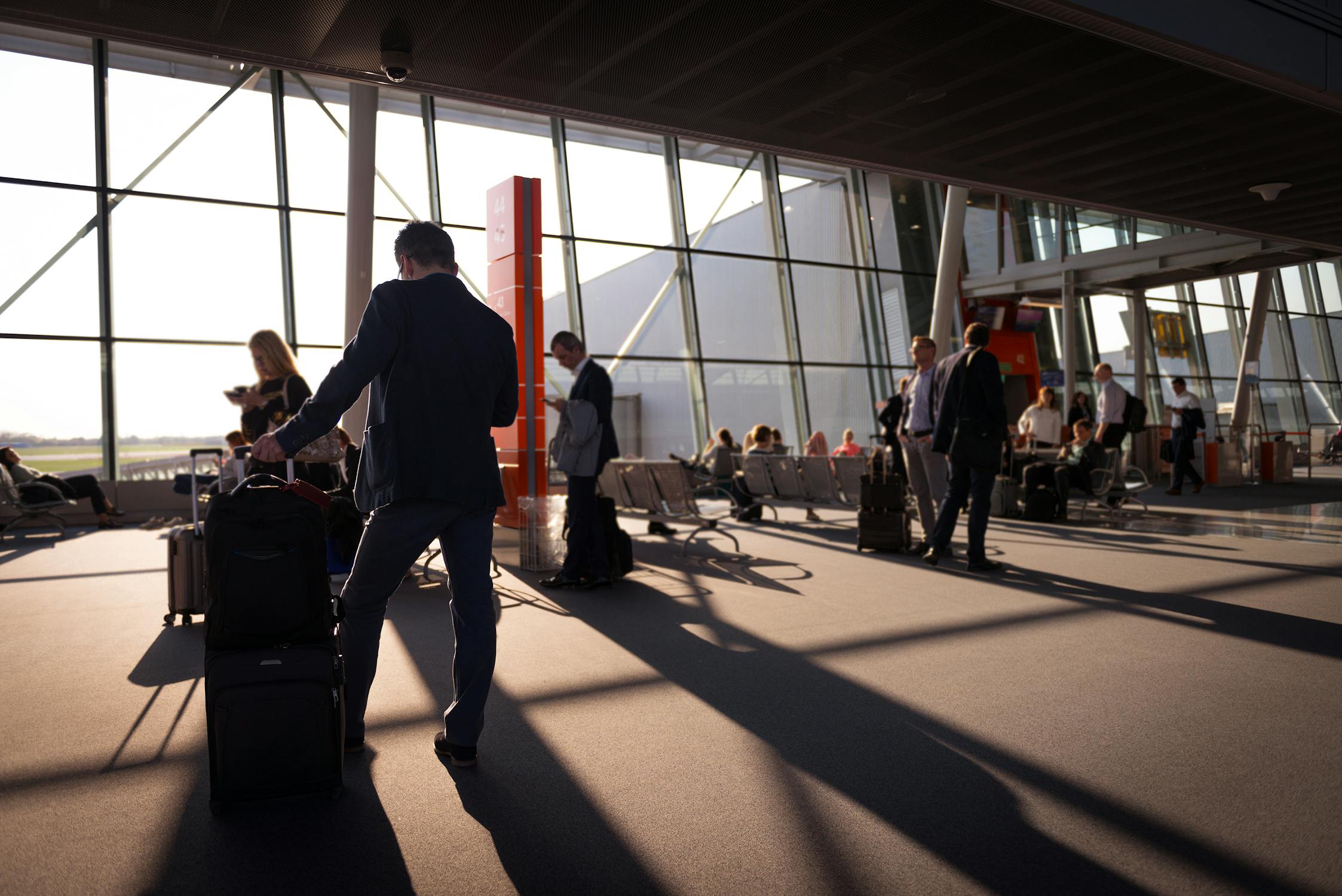 Travelers with luggage at an airport terminal: spring break travel from Syracuse Hancock faces new challenges in 2026 (Photo: Pexels)