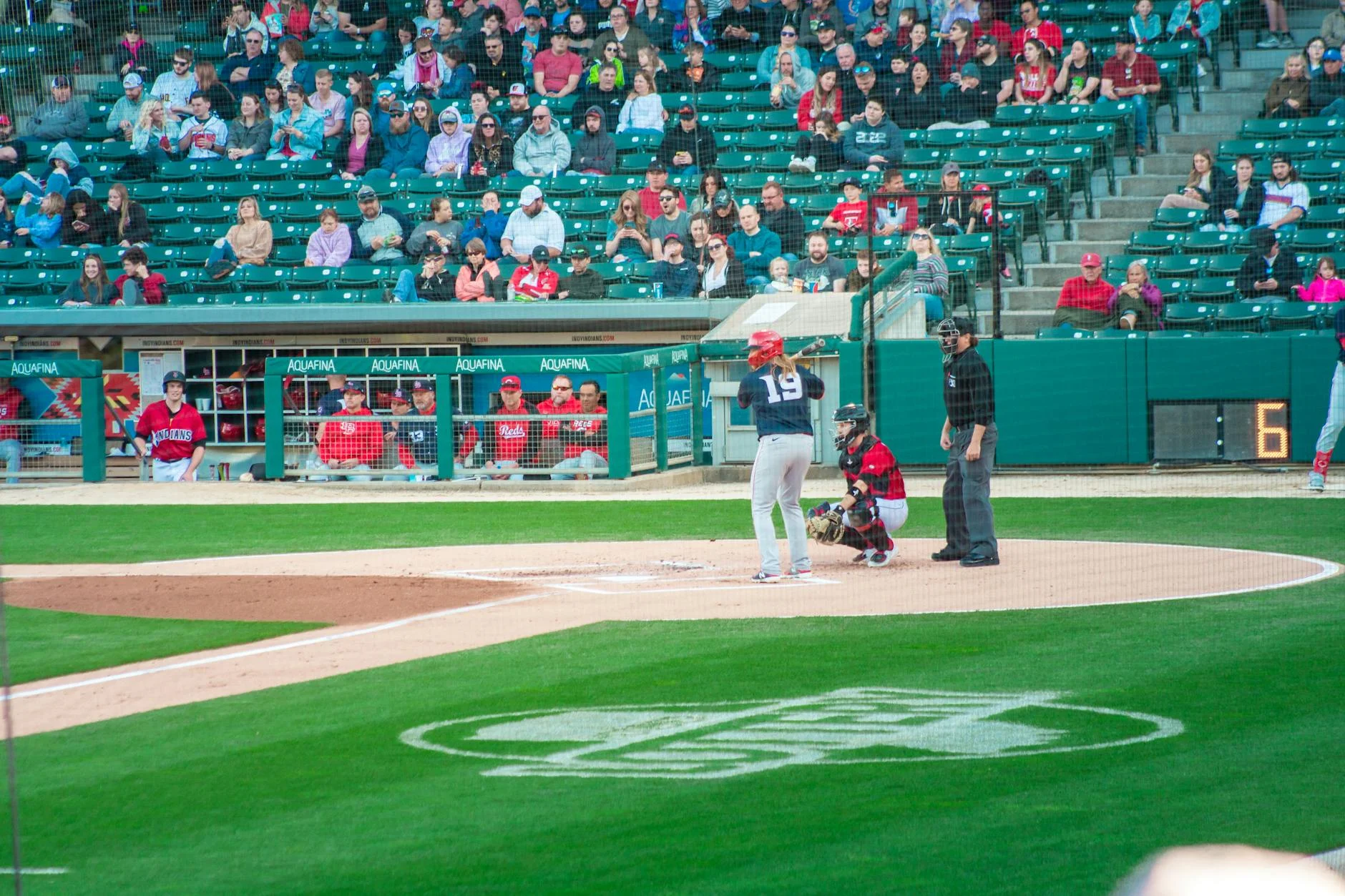 Minor league baseball game with players and fans in stadium