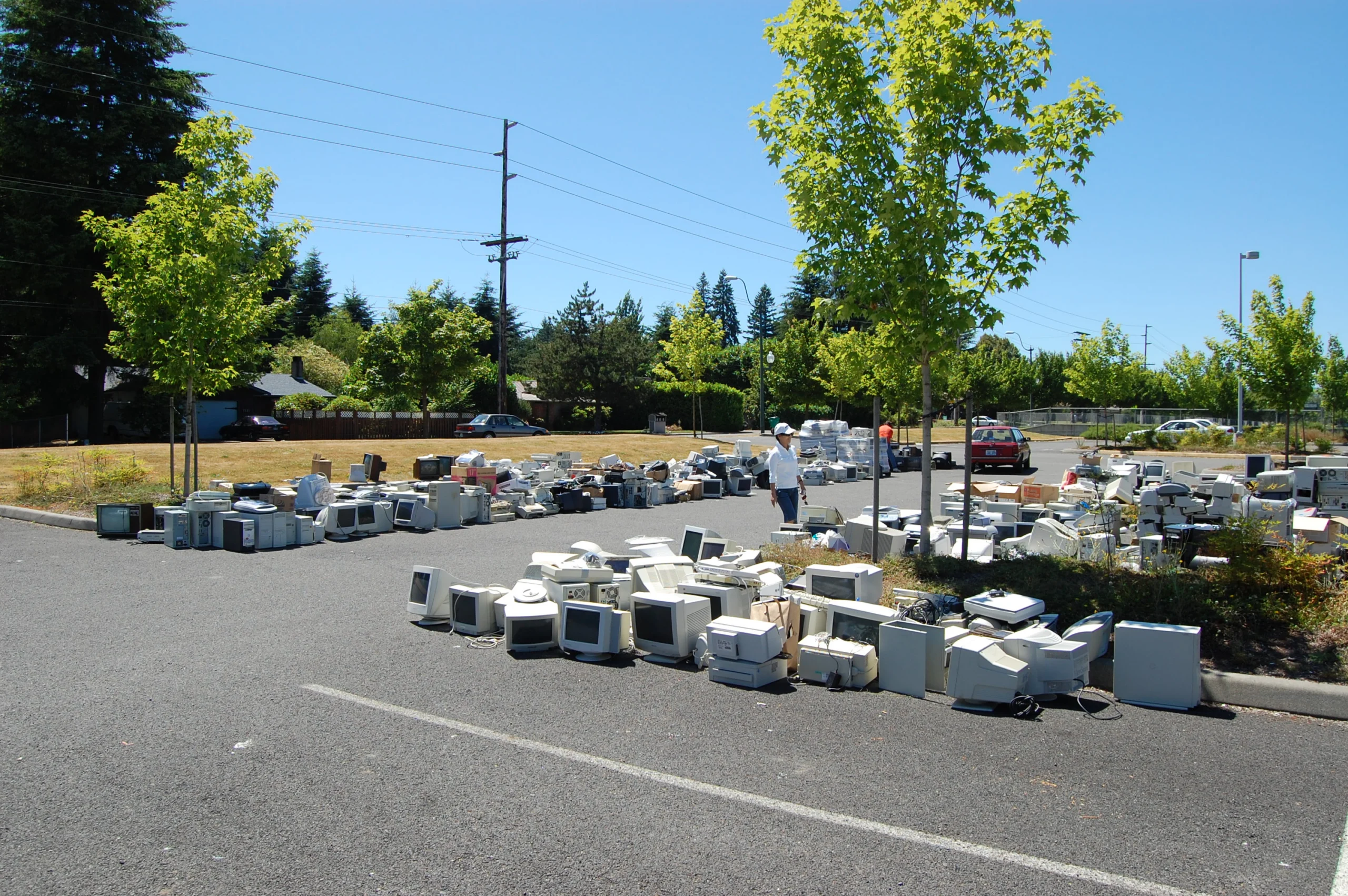 Computers and electronics lined up for recycling at a collection event.