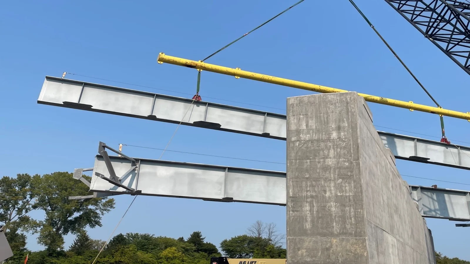 A mobile crane lifts steel girders into place on a new bridge as part of the I-81 viaduct project Contract 1 Northern Interchange in Syracuse