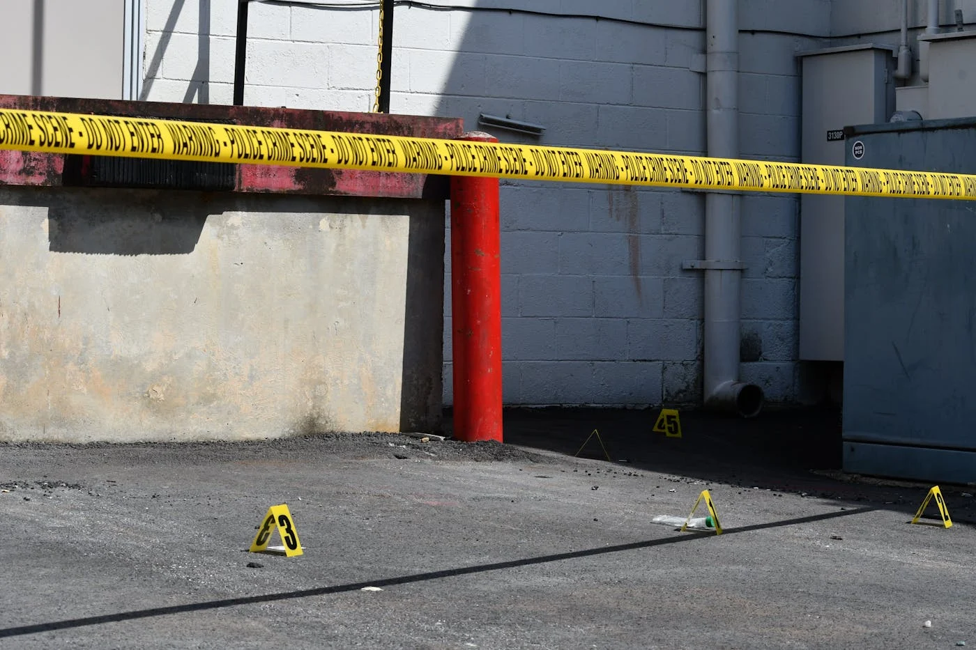 Crime scene tape and evidence markers at a commercial building, Syracuse police investigating vending machine explosion at 404 Oak Street