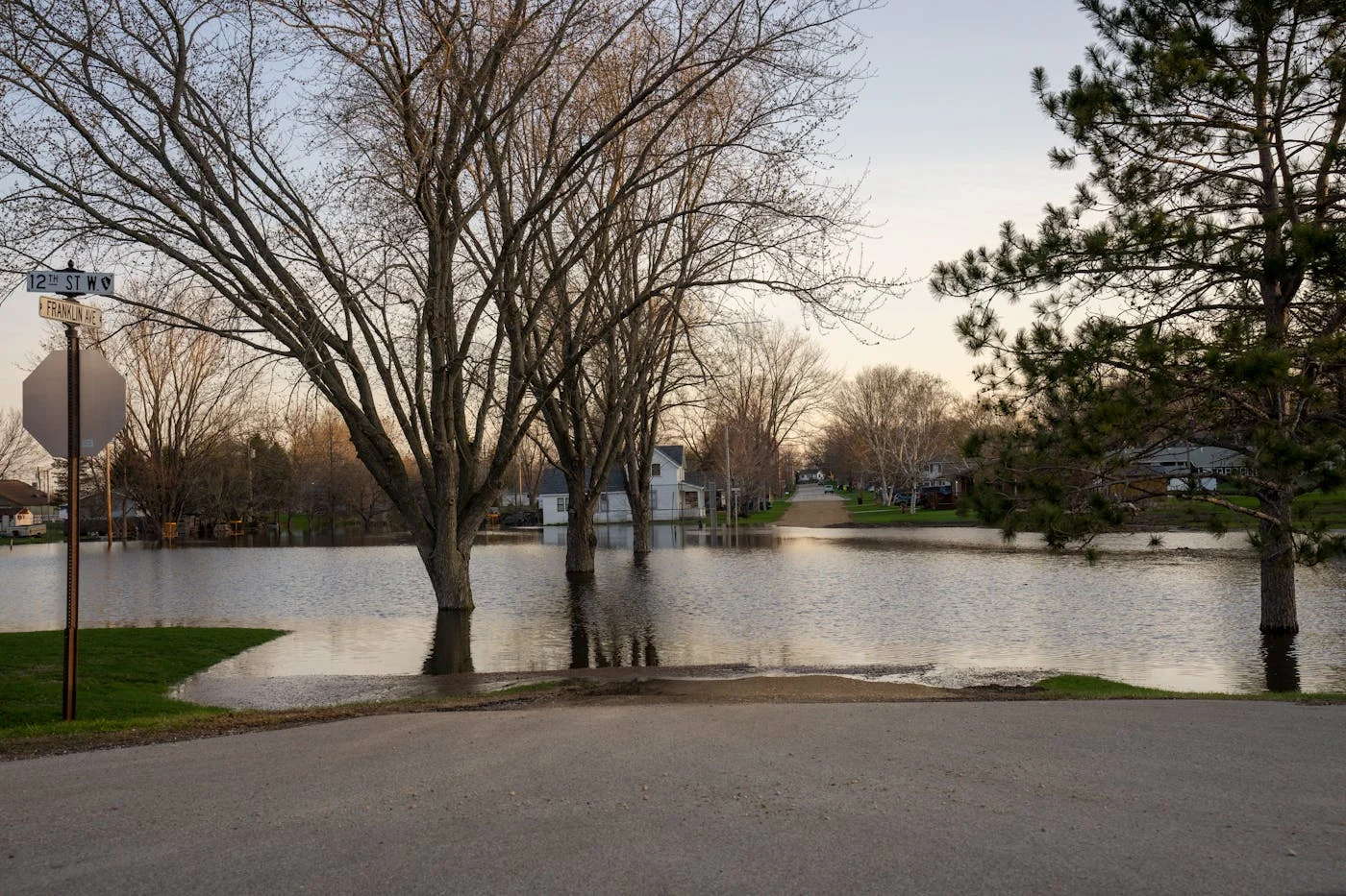Flooded residential street with spring floodwaters covering the road — Oneida Lake flooding shuts down Beach Road in Cicero every spring