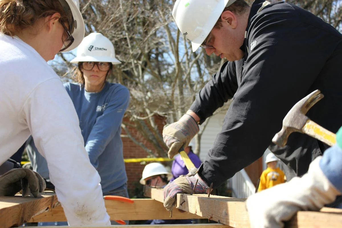 Volunteers working together to build a house frame, Sleep in Heavenly Peace bed building