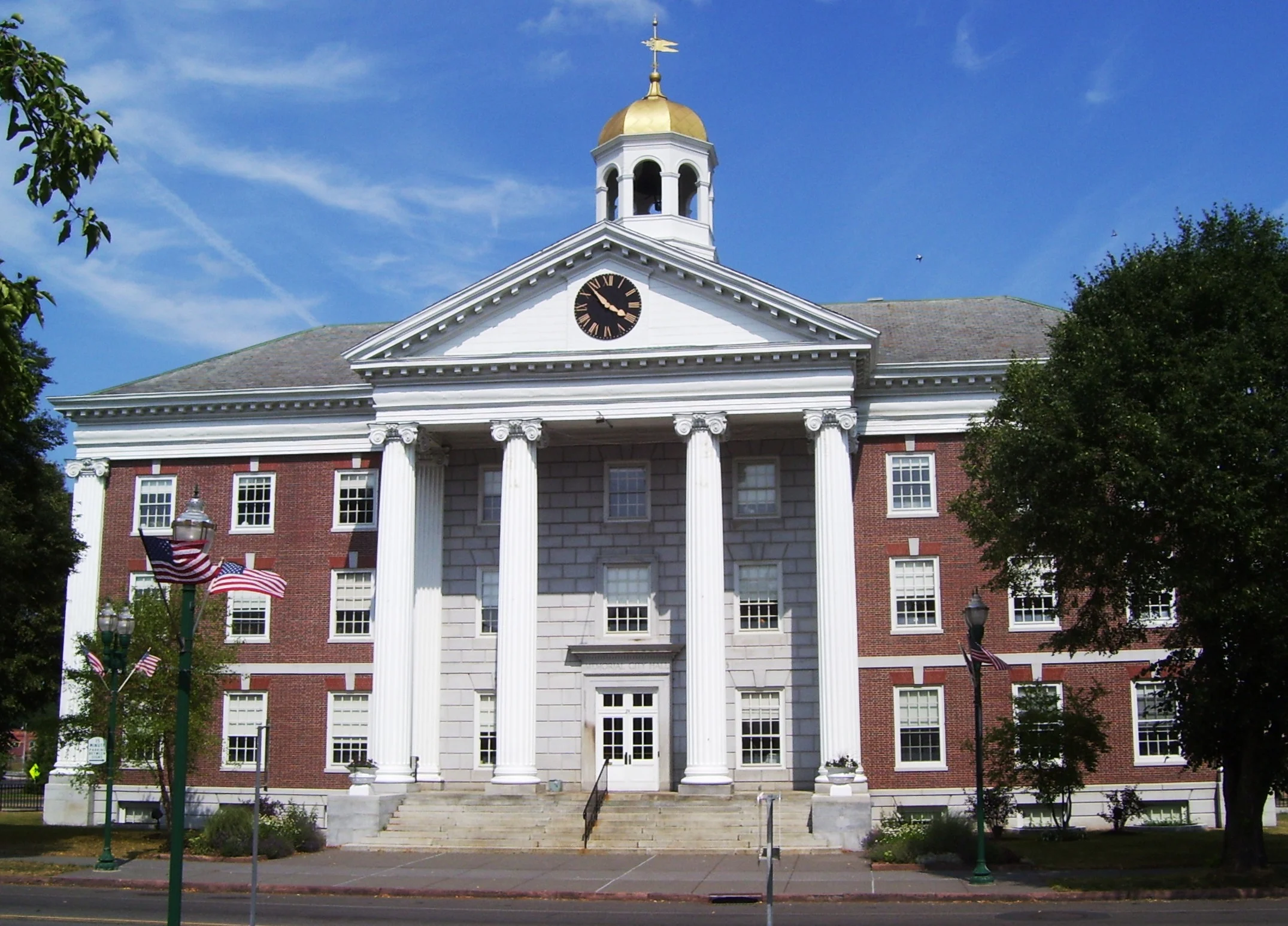 Memorial City Hall in Auburn NY, a brick building with white columns and a gold cupola
