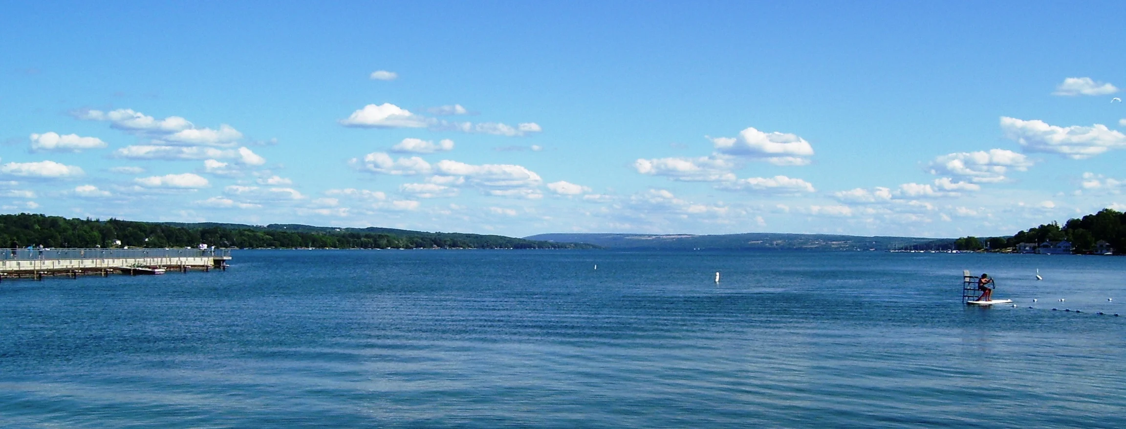 Skaneateles Lake under a blue summer sky seen from Clift Park in the village of Skaneateles