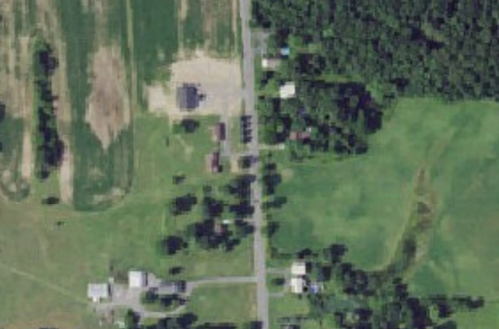 Aerial view of 8075 Plainville Road in Lysander, near the West Genesee Road intersection. The parcel holds a house and m