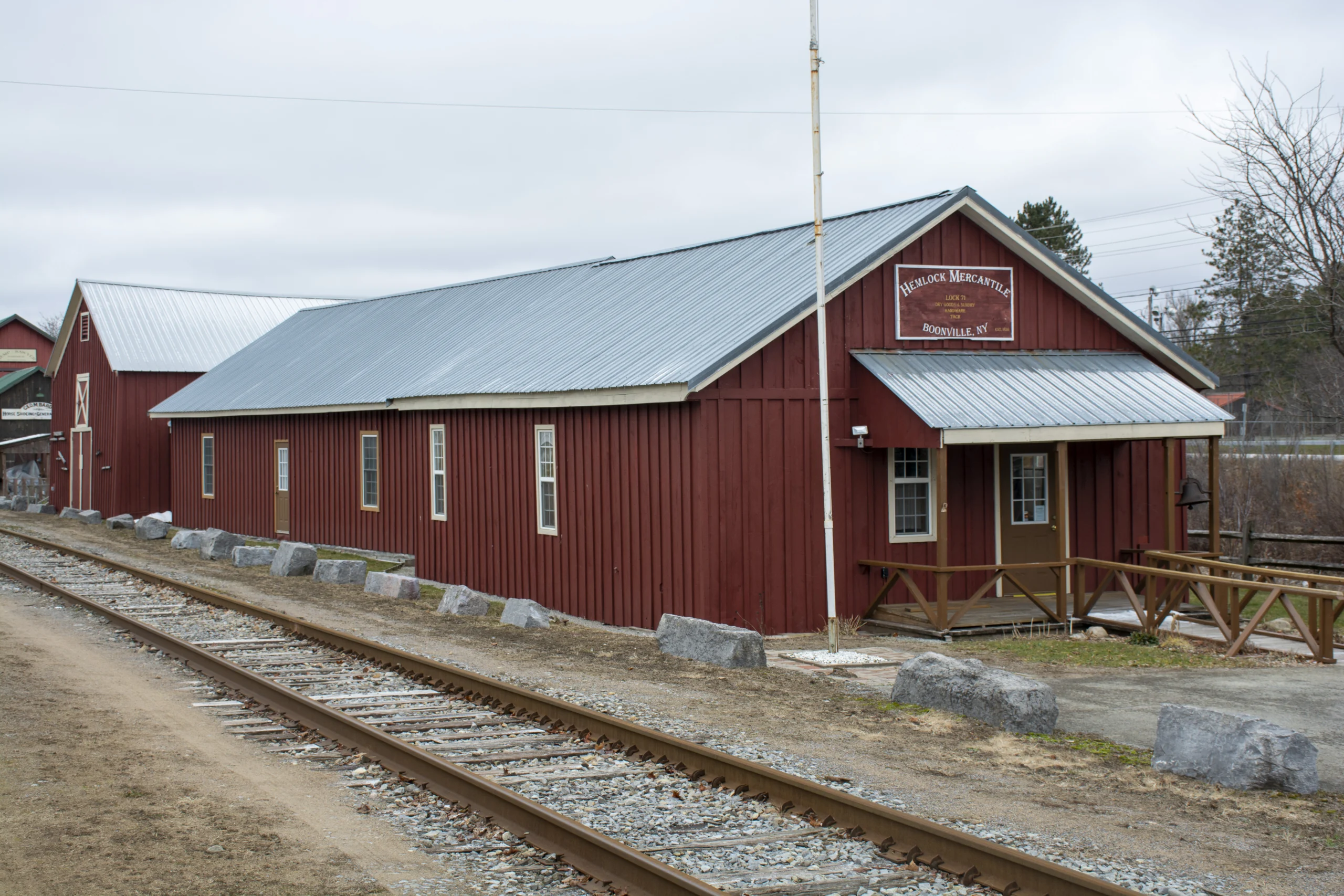 A long red wooden canal warehouse beside railroad tracks in Boonville New York