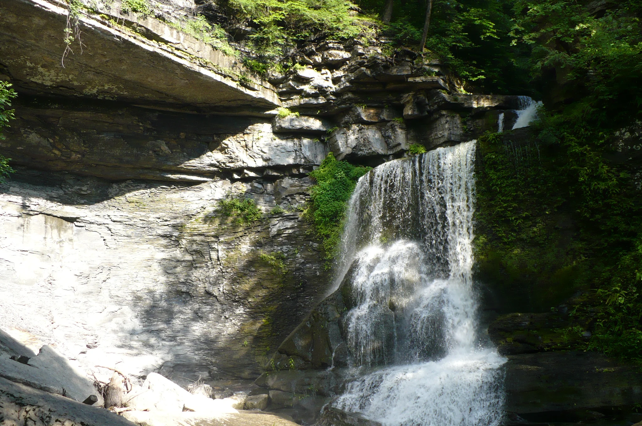 The Cowsheds waterfall pouring over layered rock ledges inside Fillmore Glen State Park