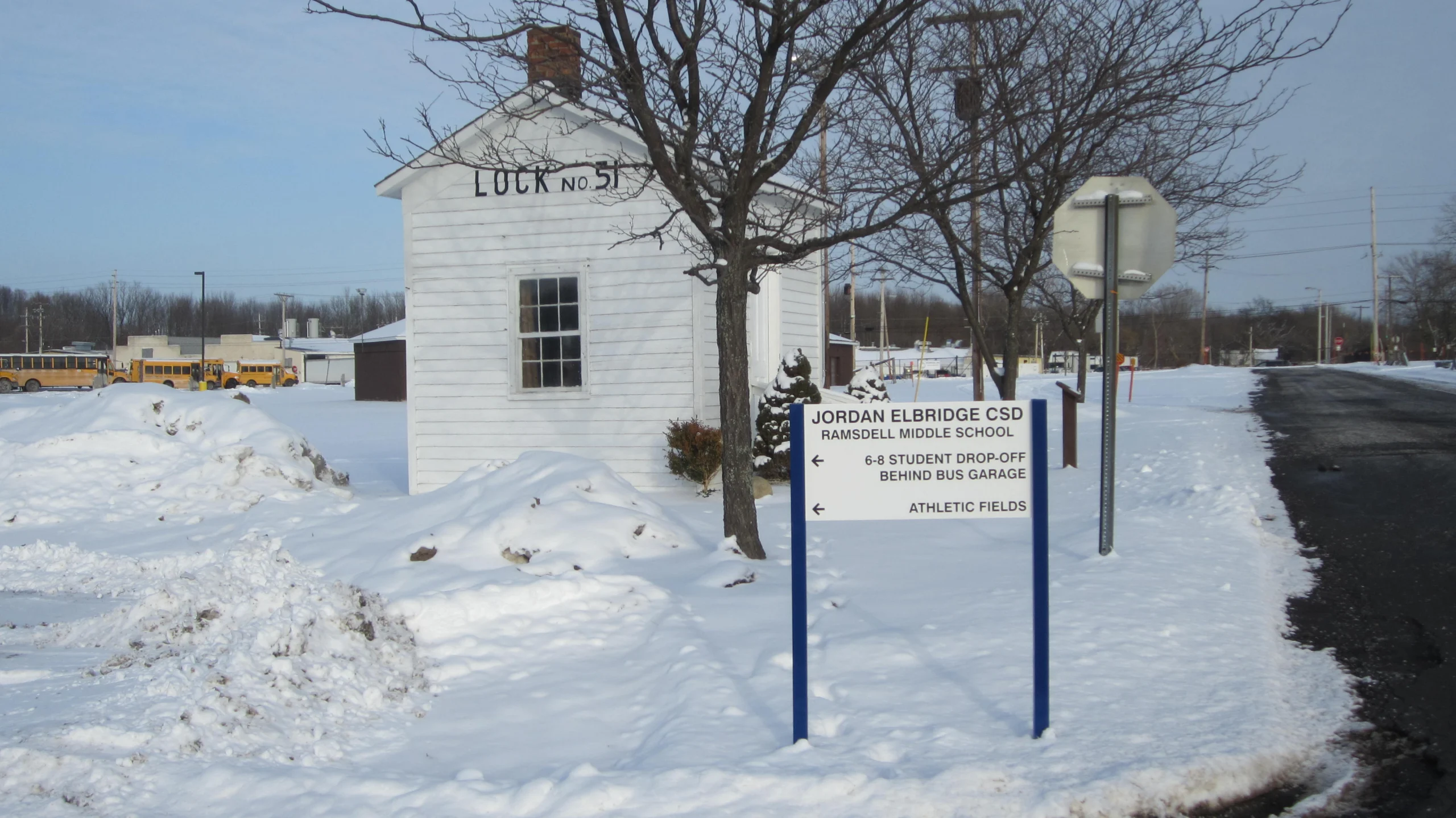 The white Lock No. 51 canal building in Jordan with a Jordan Elbridge CSD sign in the foreground