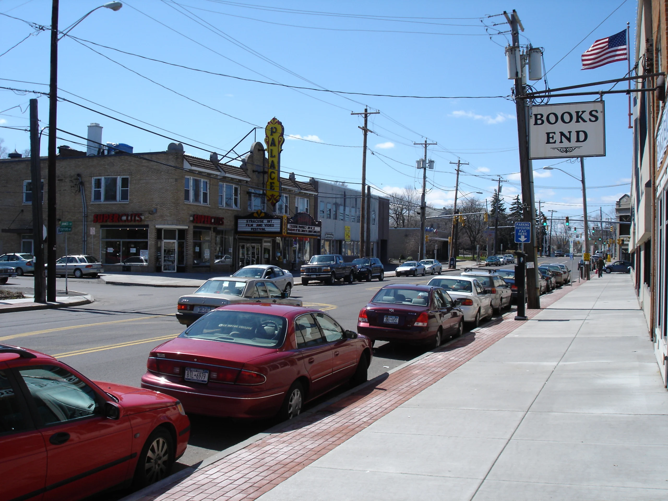 James Street in the Eastwood neighborhood of Syracuse with parked cars, the Books End sign and the Palace Theatre marquee