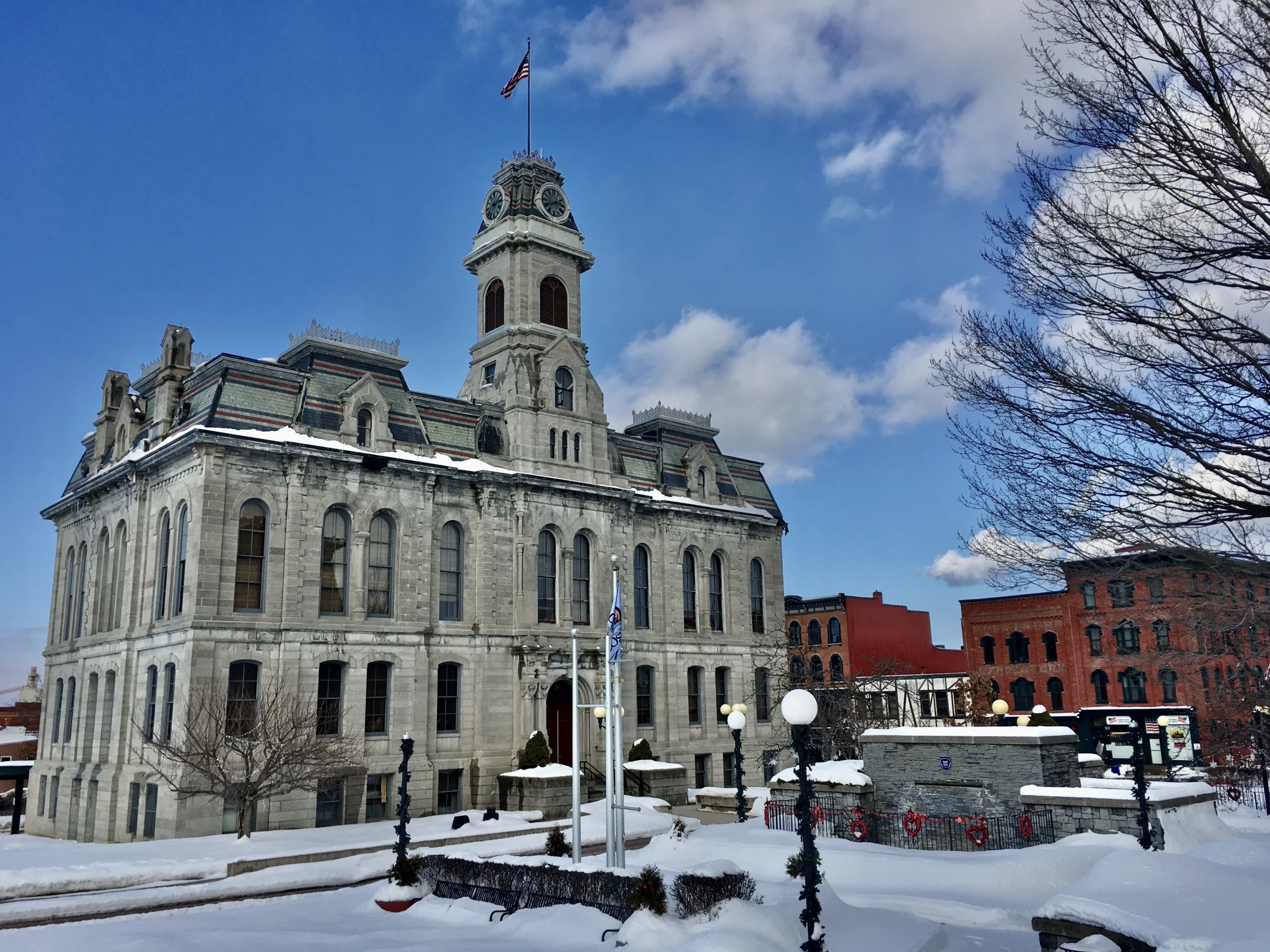 The stone Oswego City Hall building with its clock tower under a blue winter sky