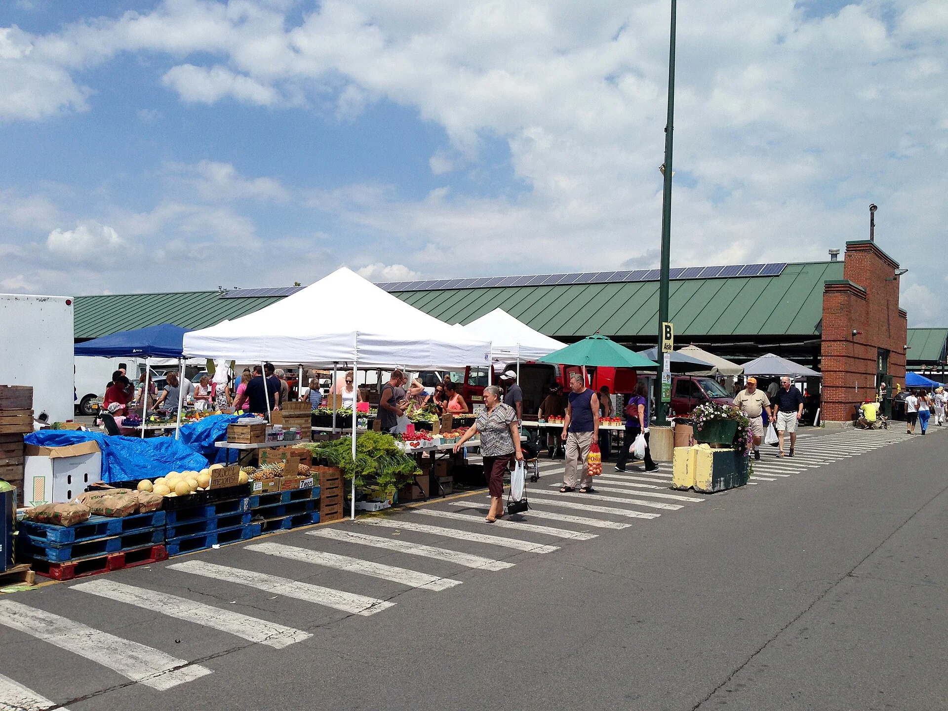 White tents, produce stands and shoppers at the Central New York Regional Market
