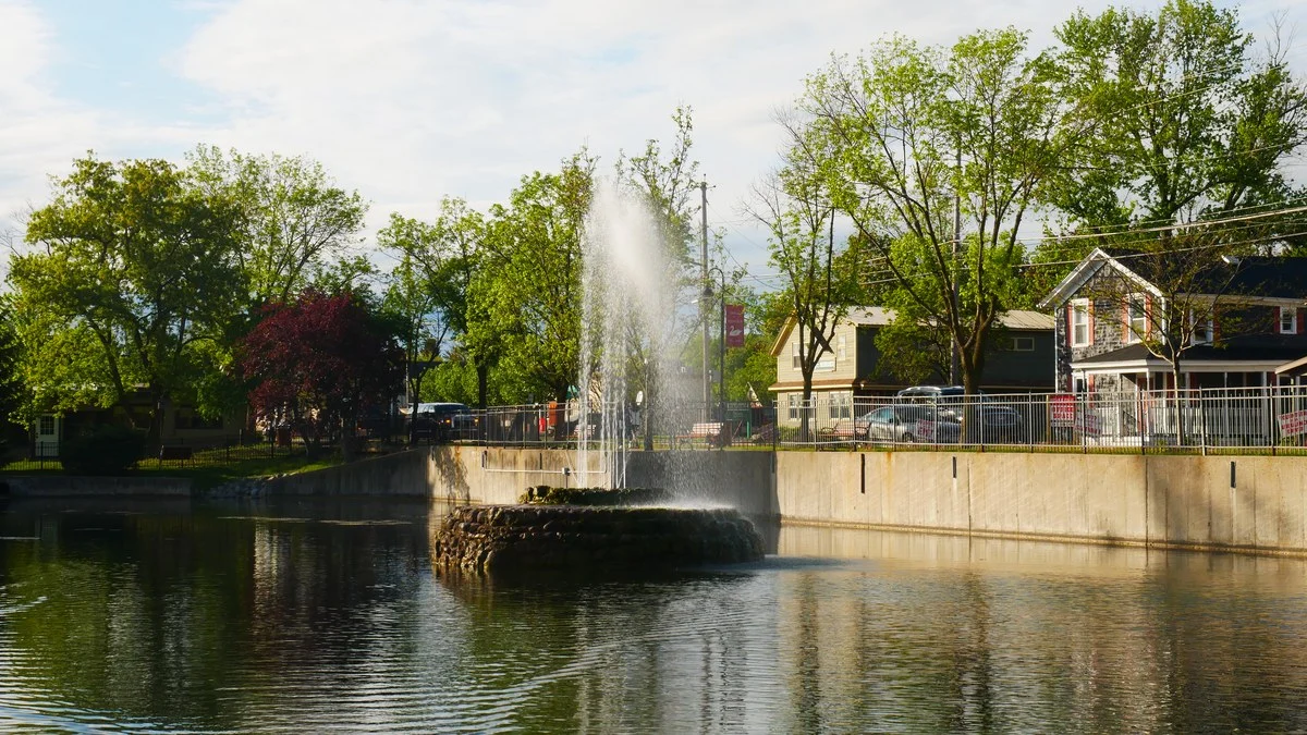 The Swan Pond in the Village of Manlius, New York, with its aerating fountain and Fayette Street homes in the background.